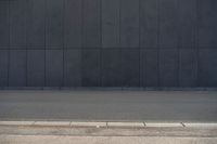 a person wearing a face mask walking across an empty street with a skateboard in the foreground