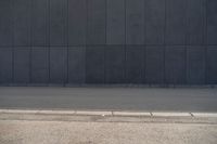 a person wearing a face mask walking across an empty street with a skateboard in the foreground