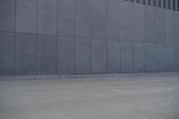 a person wearing a face mask walking across an empty street with a skateboard in the foreground