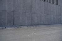 a person wearing a face mask walking across an empty street with a skateboard in the foreground