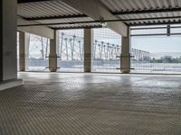 there is an empty floor with large windows at this level of the station with high power lines outside