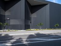 black building with white roof and tall trees in front of it in daytime day with clear blue sky