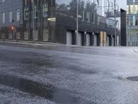 a wet street that looks like it's raining down from the sky and in front of buildings