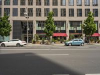 cars and pedestrians are parked at the curb in front of an older office building that is surrounded by modern architecture