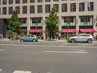 cars and pedestrians are parked at the curb in front of an older office building that is surrounded by modern architecture