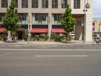 cars and pedestrians are parked at the curb in front of an older office building that is surrounded by modern architecture