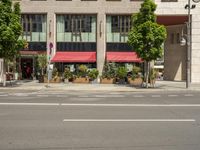 cars and pedestrians are parked at the curb in front of an older office building that is surrounded by modern architecture