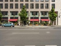 cars and pedestrians are parked at the curb in front of an older office building that is surrounded by modern architecture