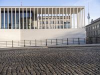 the building has multiple levels of windows and is constructed out of bricks and stone block