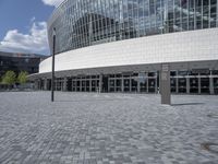 a large building with a lot of glass windows on the outside of it with the sun shining