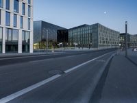 a street that has some buildings on it next to some concrete pillars and a small fire hydrant