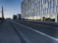 a street that has some buildings on it next to some concrete pillars and a small fire hydrant