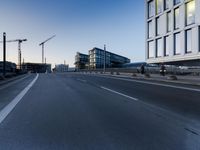 a street that has some buildings on it next to some concrete pillars and a small fire hydrant