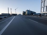 a street that has some buildings on it next to some concrete pillars and a small fire hydrant