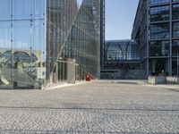 a black fire hydrant sitting in front of a glass building in europes capital