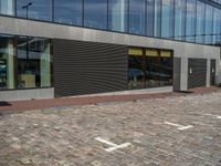 there is a yellow frisbee on the pavement outside a building with a large glass window