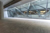 a person walks outside a large building through the glassy walls of it's entrance