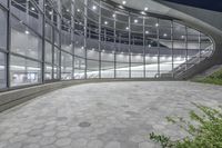 view of the outside of an office building that contains glass and steel windows, with a tiled floor below