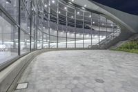 view of the outside of an office building that contains glass and steel windows, with a tiled floor below