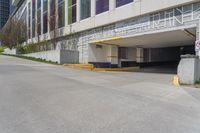 an empty parking garage is located by the side of the road in front of a tall building