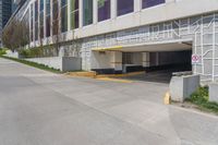 an empty parking garage is located by the side of the road in front of a tall building