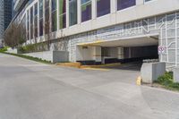 an empty parking garage is located by the side of the road in front of a tall building