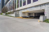 an empty parking garage is located by the side of the road in front of a tall building