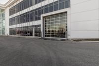 potholes in a parking lot full of water near an office building with glass windows
