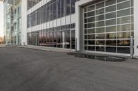 potholes in a parking lot full of water near an office building with glass windows