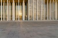 an empty room with lots of glass walls and many columns on the inside of it