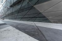 the side view of an office building showing concrete steps and a glass facade with glass panels