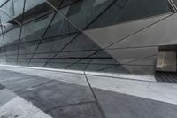 the side view of an office building showing concrete steps and a glass facade with glass panels