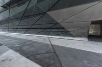 the side view of an office building showing concrete steps and a glass facade with glass panels