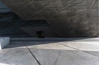 an empty city street with some people walking by it in a building made from concrete