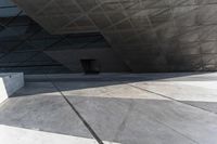 an empty city street with some people walking by it in a building made from concrete