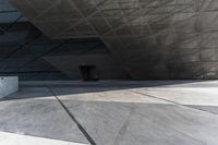 an empty city street with some people walking by it in a building made from concrete