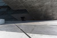 an empty city street with some people walking by it in a building made from concrete