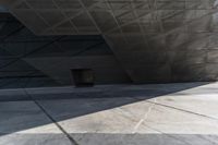 an empty city street with some people walking by it in a building made from concrete