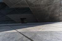 an empty city street with some people walking by it in a building made from concrete