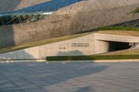 a stone building has a modern style architecture in it's centerpiece, as seen from the plaza