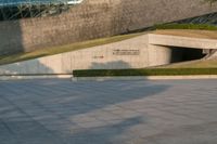 a stone building has a modern style architecture in it's centerpiece, as seen from the plaza