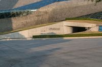 a stone building has a modern style architecture in it's centerpiece, as seen from the plaza