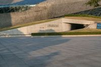 a stone building has a modern style architecture in it's centerpiece, as seen from the plaza