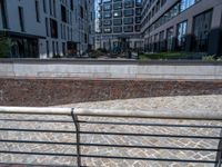 there is an empty bench along the brick path in the city area of the building