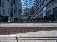 there is an empty bench along the brick path in the city area of the building