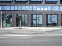 a black building with windows on the corner, and a stop sign at an intersection