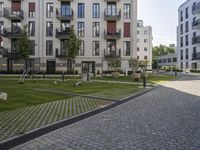 an empty street with some modern buildings and small parks near it for recreation and privacy