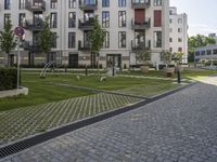 an empty street with some modern buildings and small parks near it for recreation and privacy