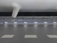 a long empty walkway in an airport with some lights lit up at the end of it