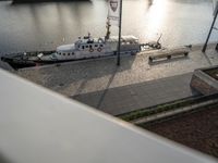 a boat sitting on top of a harbor next to a sidewalk next to a river